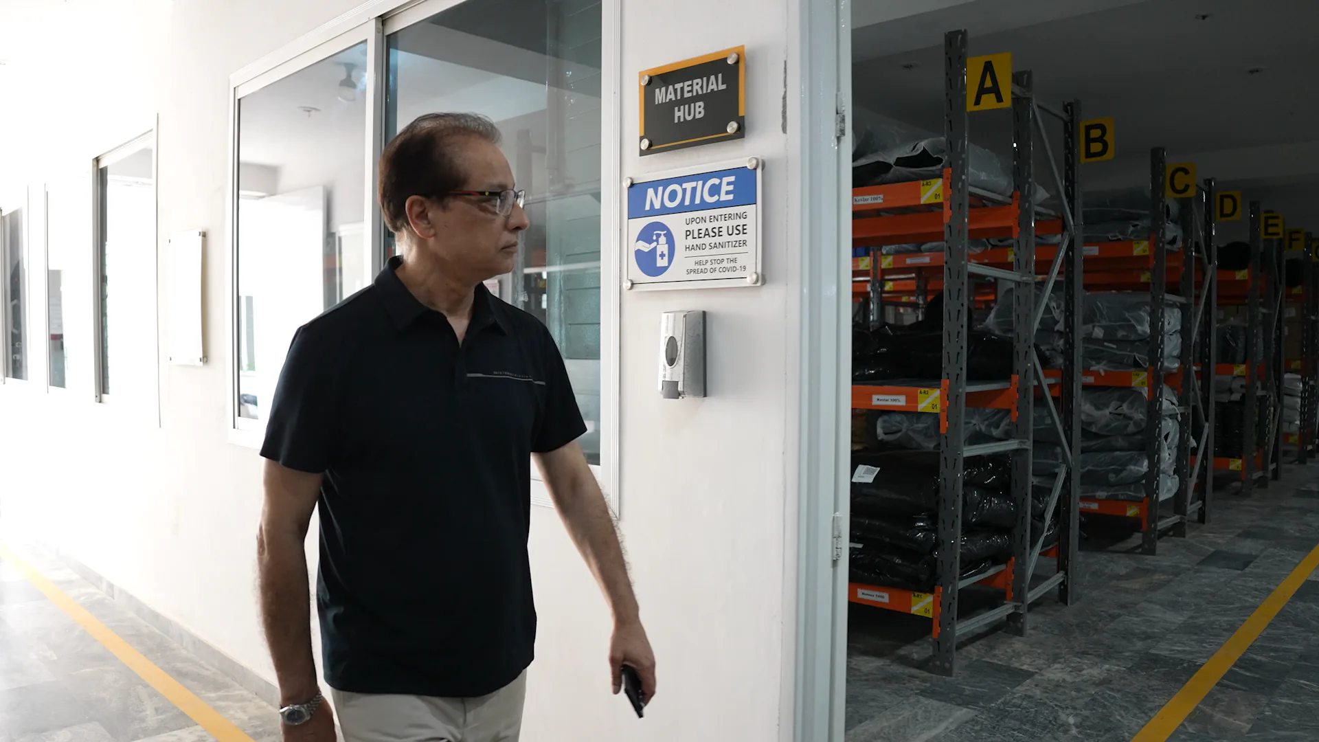 Emblon team member beside material storage racks